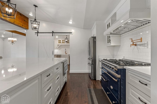 kitchen featuring custom range hood, backsplash, white cabinets, a barn door, and stainless steel appliances