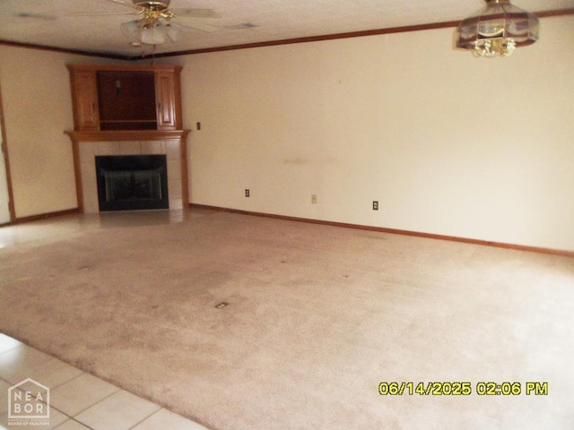 805 Cherokee Dr, Newport, AR 72112 - unfurnished living room with a tiled fireplace, a ceiling fan, crown molding, and light colored carpet