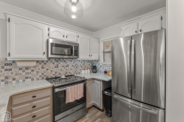 1300 S Church St S, Jonesboro, AR 72401 - kitchen with stainless steel appliances, a textured ceiling, backsplash, white cabinetry, and ornamental molding