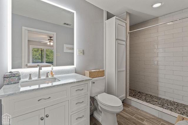 1300 S Church St S, Jonesboro, AR 72401 - full bathroom with a tile shower, vanity, toilet, wood finished floors, and a ceiling fan