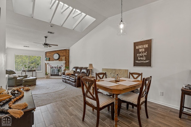 1300 S Church St S, Jonesboro, AR 72401 - dining space with wood finished floors, ceiling fan, baseboards, a brick fireplace, and high vaulted ceiling