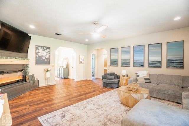 2 Deer Run, Clarksville, AR 72830 - living area featuring wood finished floors, a glass covered fireplace, ceiling fan, recessed lighting, and arched walkways