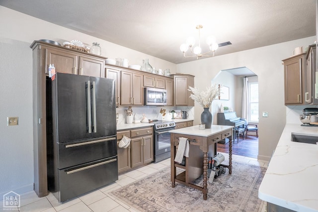 2 Deer Run, Clarksville, AR 72830 - kitchen featuring appliances with stainless steel finishes, arched walkways, a chandelier, decorative light fixtures, and light tile patterned floors