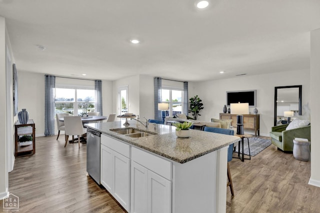 107 Terry Dr, Brookland, AR 72417 - kitchen featuring dishwasher, a sink, an island with sink, light stone counters, and baseboards