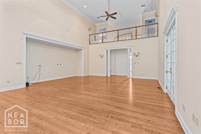 3201 S 2nd Ave S, Paragould, AR 72450 - unfurnished living room featuring ceiling fan, ornamental molding, light wood finished floors, and a high ceiling