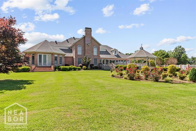 3201 S 2nd Ave S, Paragould, AR 72450 - back of property with a gazebo, a lawn, and a chimney