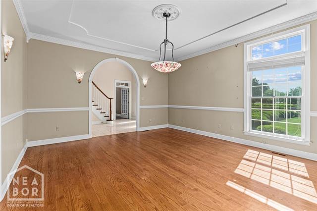 3201 S 2nd Ave S, Paragould, AR 72450 - unfurnished room with crown molding, arched walkways, plenty of natural light, and wood finished floors