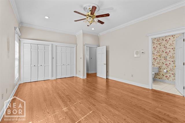 3201 S 2nd Ave S, Paragould, AR 72450 - unfurnished bedroom featuring ornamental molding, light wood finished floors, two closets, recessed lighting, and ensuite bathroom