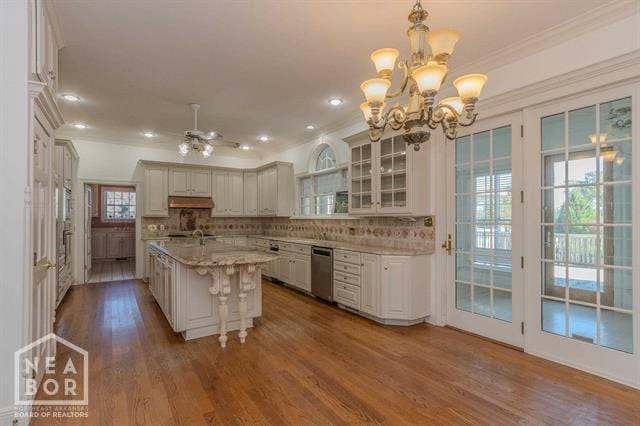 3201 S 2nd Ave S, Paragould, AR 72450 - kitchen with stainless steel dishwasher, ornamental molding, a chandelier, wood finished floors, and glass insert cabinets