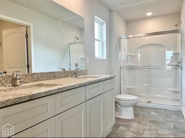 bathroom featuring a sink, toilet, and a shower stall