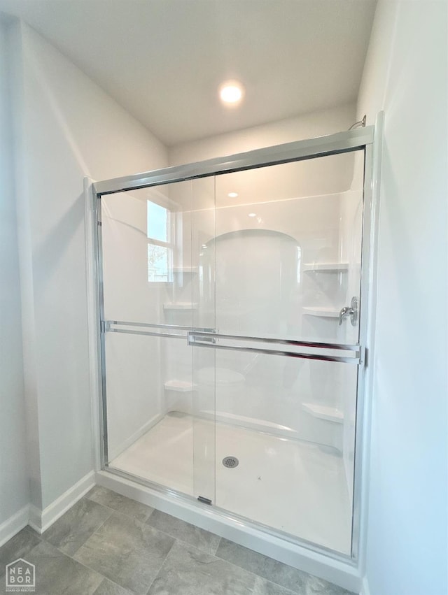 bathroom featuring baseboards and a stall shower