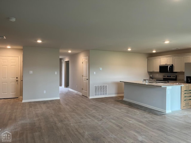 119 Terry Dr, Brookland, AR 72417 - kitchen featuring stainless steel electric stove, baseboards, recessed lighting, wood finished floors, and open floor plan