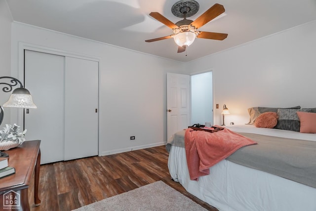 bedroom with a closet, wood finished floors, ornamental molding, ceiling fan, and baseboards