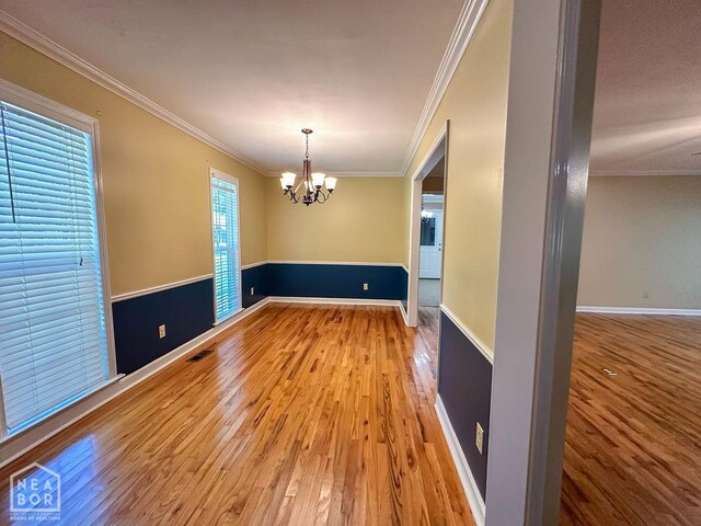 3013 Park Hill Blvd, Jonesboro, AR 72404 - spare room featuring a chandelier, wood finished floors, crown molding, and baseboards