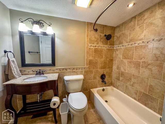 3013 Park Hill Blvd, Jonesboro, AR 72404 - full bathroom with a sink, toilet, a textured ceiling, washtub / shower combination, and tile walls