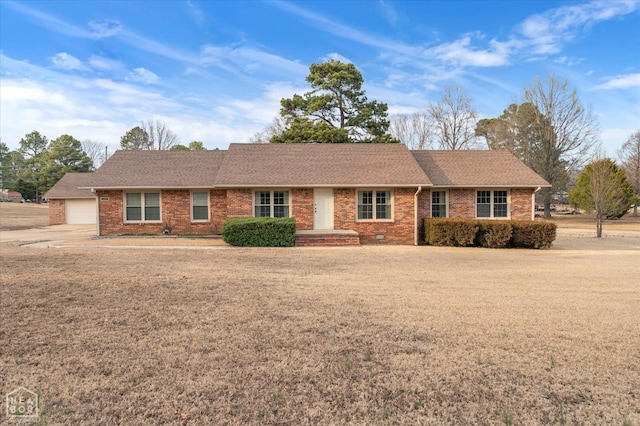 ranch-style home featuring roof with shingles, brick siding, and a front lawn