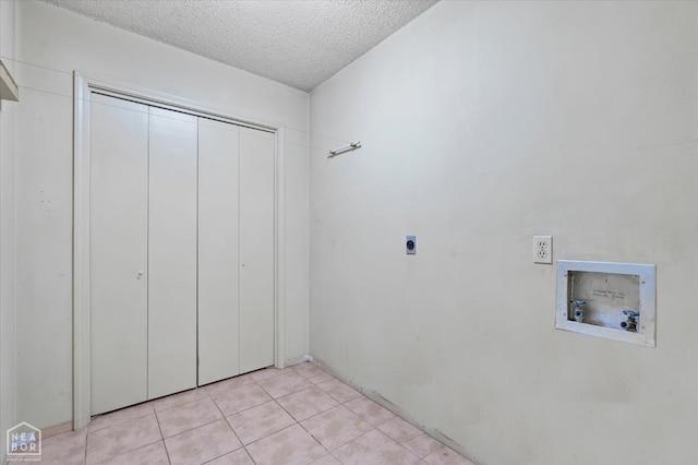 laundry area featuring light tile patterned floors, laundry area, a textured ceiling, hookup for an electric dryer, and hookup for a washing machine