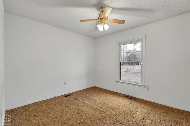 carpeted empty room featuring visible vents, baseboards, a ceiling fan, and a textured ceiling