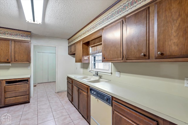 kitchen featuring light tile patterned floors, dishwasher, a sink, light countertops, and a textured ceiling