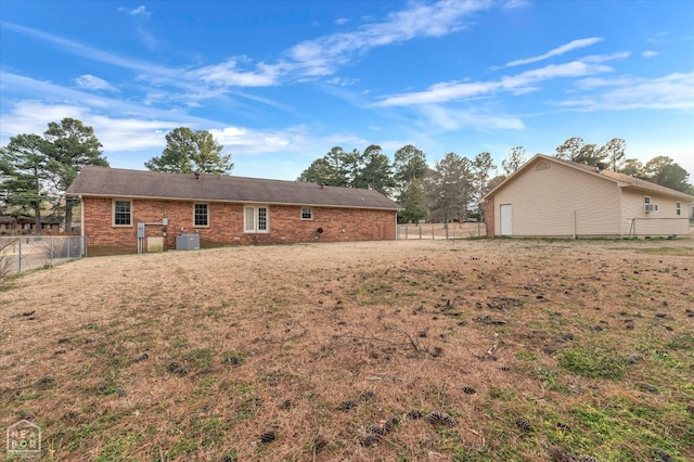 back of property featuring brick siding, central air condition unit, and fence