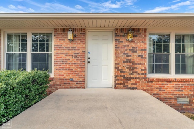 view of exterior entry featuring brick siding