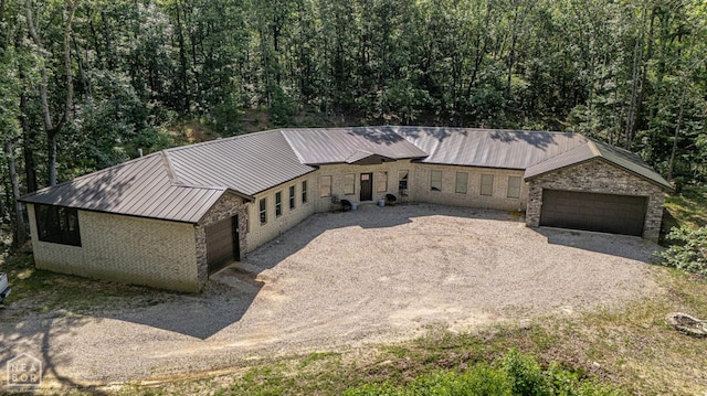 8203 Oak Creek Ln, Harrisburg, AR 72432 - view of front of property featuring a metal roof, stone siding, a wooded view, driveway, and a standing seam roof