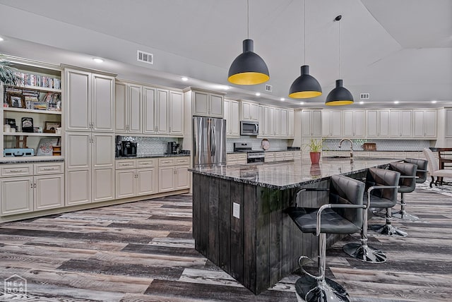 8203 Oak Creek Ln, Harrisburg, AR 72432 - kitchen with stainless steel appliances, a breakfast bar, dark stone countertops, tasteful backsplash, and lofted ceiling