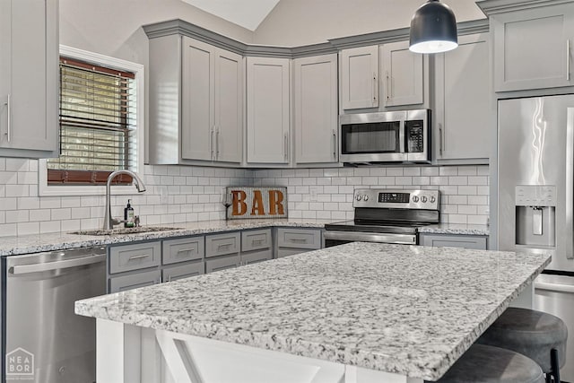 506 S Edmonds St, Monette, AR 72447 - kitchen with appliances with stainless steel finishes, gray cabinetry, a sink, a breakfast bar area, and vaulted ceiling