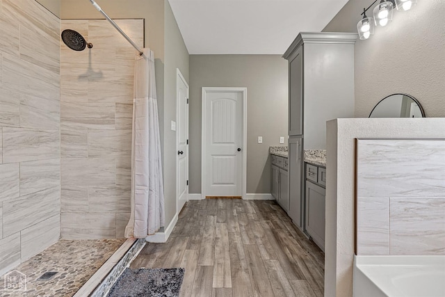 506 S Edmonds St, Monette, AR 72447 - full bath featuring tiled shower, wood finished floors, vanity, a tub to relax in, and baseboards