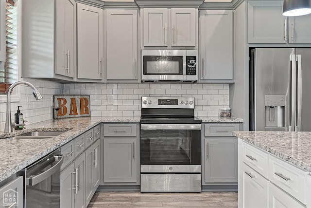 506 S Edmonds St, Monette, AR 72447 - kitchen featuring appliances with stainless steel finishes, gray cabinets, a sink, and light wood-style flooring
