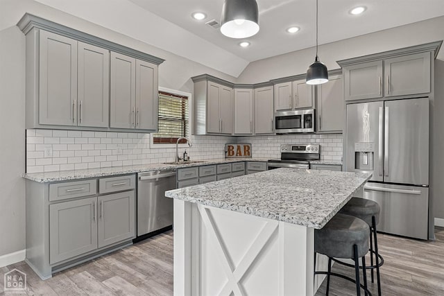 506 S Edmonds St, Monette, AR 72447 - kitchen with appliances with stainless steel finishes, gray cabinets, a sink, light stone counters, and a breakfast bar