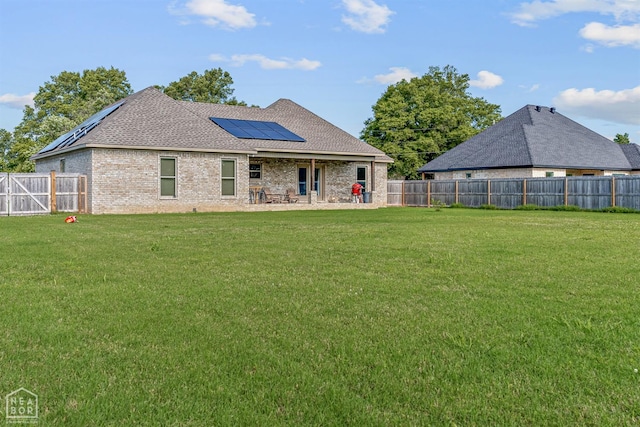 506 S Edmonds St, Monette, AR 72447 - rear view of property with solar panels, a patio area, brick siding, and roof with shingles