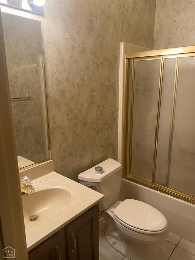 2604 Michael Ln, Jonesboro, AR 72404 - bathroom featuring combined bath / shower with glass door, vanity, wallpapered walls, tile patterned floors, and toilet