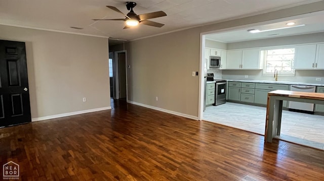 617 S Clayton St, Rector, AR 72461 - interior space featuring baseboards, ornamental molding, a ceiling fan, a sink, and wood finished floors