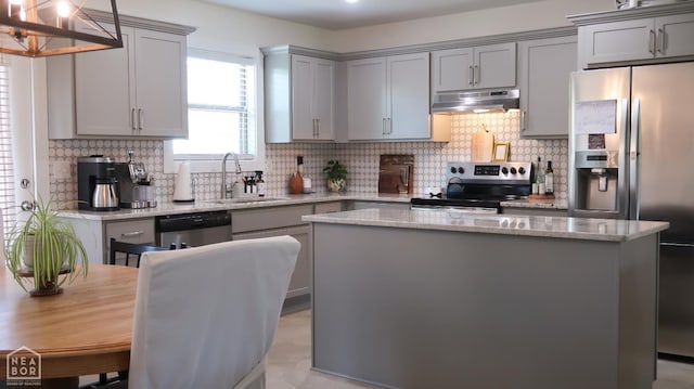 305 Stella Dr, Bono, AR 72416 - kitchen featuring stainless steel appliances, gray cabinets, under cabinet range hood, a center island, and light stone countertops