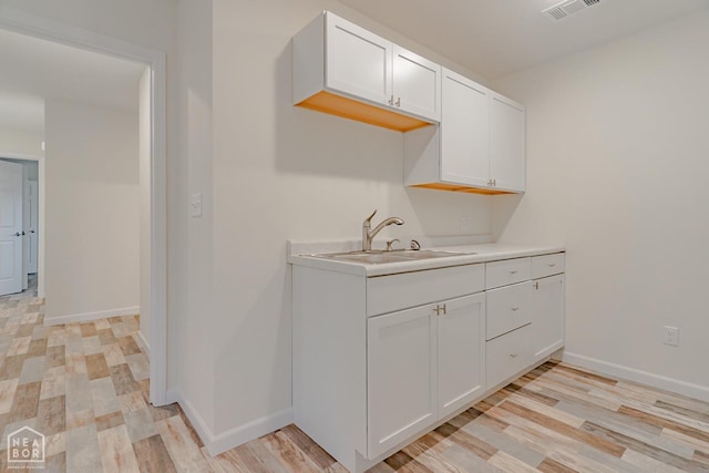 2516 Rebecca Dr, Pocahontas, AR 72455 - kitchen featuring light countertops, light wood-style flooring, and white cabinets