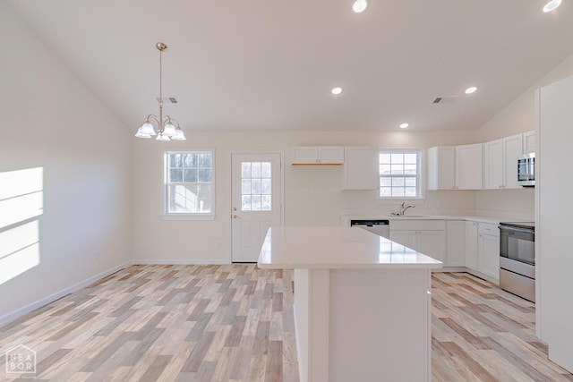 2516 Rebecca Dr, Pocahontas, AR 72455 - kitchen with appliances with stainless steel finishes, vaulted ceiling, light wood-style floors, light countertops, and white cabinetry