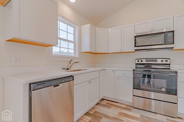 2516 Rebecca Dr, Pocahontas, AR 72455 - kitchen with stainless steel appliances, light wood-style flooring, white cabinetry, lofted ceiling, and light countertops