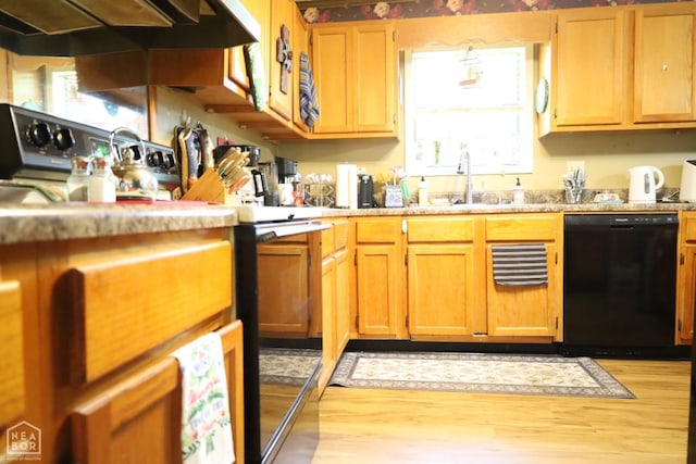 kitchen featuring a sink, light wood-style floors, light countertops, dishwasher, and under cabinet range hood