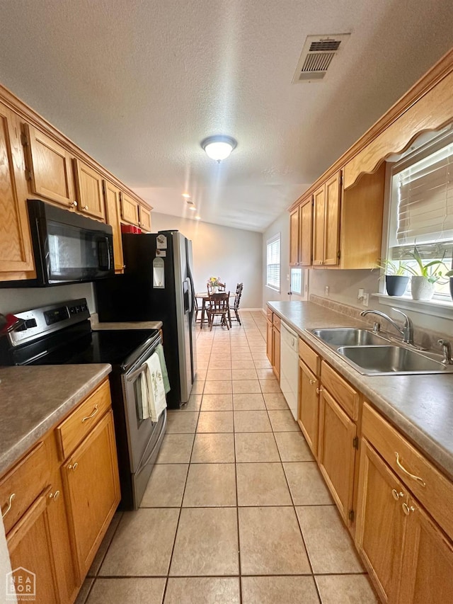 4907 Stidham Ln, Paragould, AR 72450 - kitchen with stainless steel electric range, black microwave, dishwasher, light tile patterned floors, and a textured ceiling