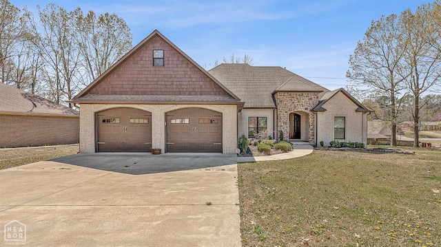 french country inspired facade with an attached garage, brick siding, concrete driveway, a front lawn, and a shingled roof