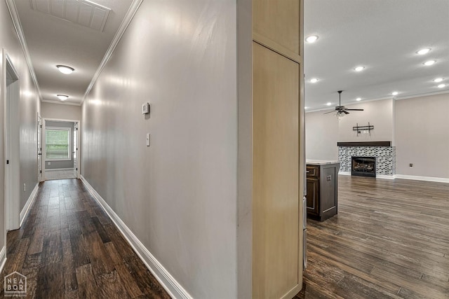 hall with crown molding, visible vents, dark wood-style flooring, baseboards, and recessed lighting