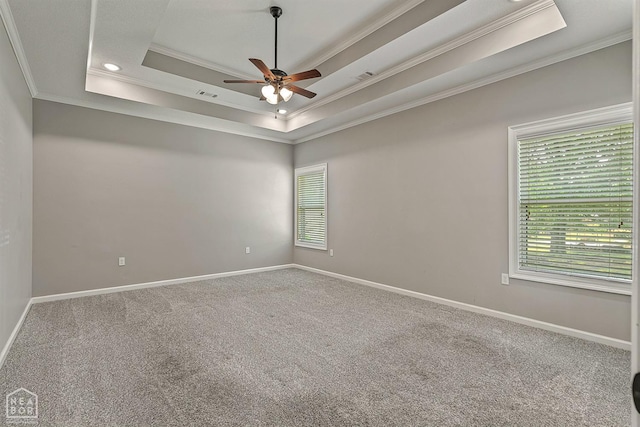 carpeted spare room featuring a ceiling fan, a wealth of natural light, and crown molding