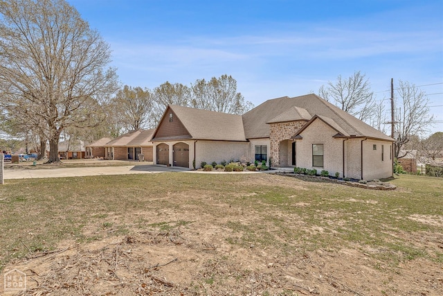 view of front facade with a front lawn, brick siding, driveway, and a garage