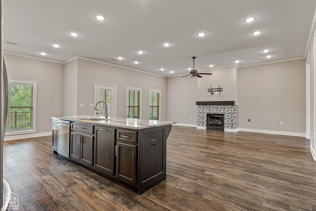 kitchen with ceiling fan, a tiled fireplace, and recessed lighting