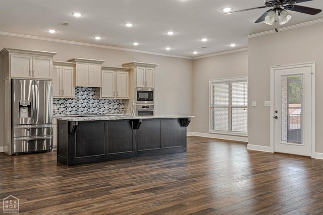 kitchen with a kitchen breakfast bar, a kitchen island with sink, dark wood-type flooring, ceiling fan, and appliances with stainless steel finishes