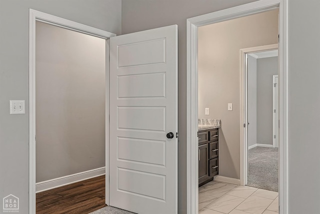 interior space with baseboards and marble finish floor