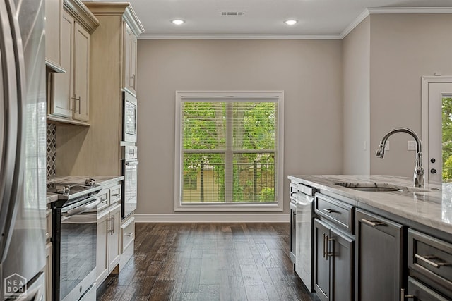 kitchen with light stone counters, visible vents, a sink, dark wood-type flooring, and stainless steel appliances