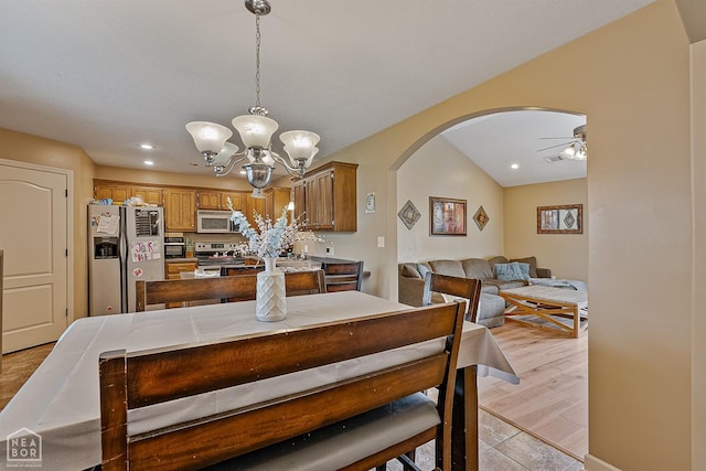 dining room with arched walkways, ceiling fan with notable chandelier, and recessed lighting