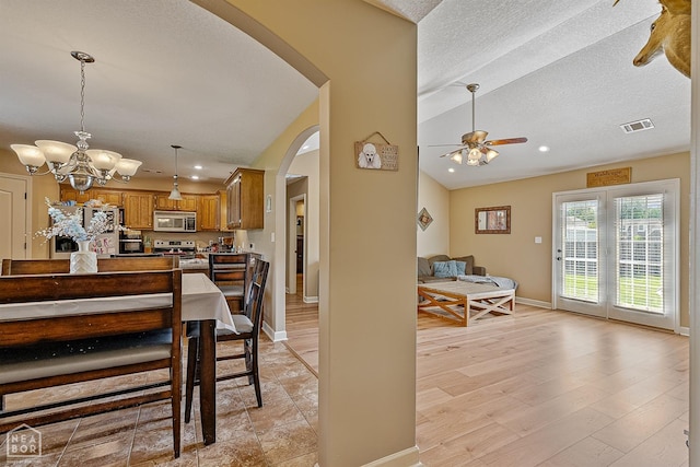 dining area with visible vents, arched walkways, baseboards, ceiling fan with notable chandelier, and recessed lighting